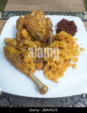 Nasi Goreng avec un poulet à moitié frit. kremes et sambal piment rouge épicé. Banque D'Images