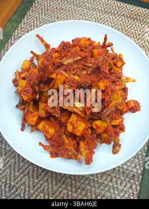 Teri Kentang Balado, un plat épicé d'anchois et de pommes de terre balado dans une sauce épicée au piment rouge d'Indonésie. Banque D'Images