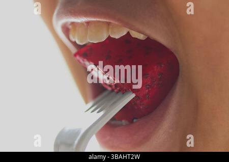 Gros plan d'une personne mangeant de délicieux fruits frais du Dragon rouge Banque D'Images