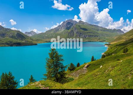 Les eaux turquoises vibrantes du lac du Mont Cenis sont encadrées par des pentes verdoyantes et des montagnes des Alpes françaises. Banque D'Images
