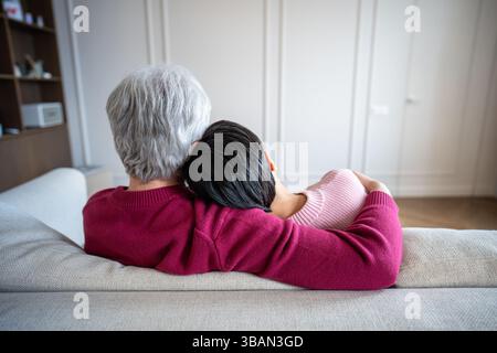 Tendre couple senior serrant dans les bras sur le canapé. Famille romantique chaleur confort relation émotionnelle Banque D'Images