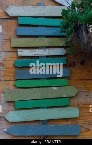 Panneau de direction de flèche en bois coloré sur fond en bois rustique Banque D'Images