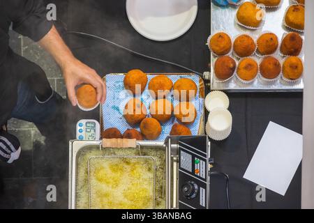 Vue de haut en bas des boulettes de riz arancini en cours de préparation au Sicily Fest à Brick Lane, Londres, Angleterre Banque D'Images