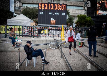 Tel Aviv, Israël. 12 mai 2025. Les Israéliens sont assis à côté d’une horloge, comptant les jours depuis l’attaque du 7 octobre, sur la place des otages à tel Aviv, le lundi 12 mai 2025. Des centaines de personnes se sont rassemblées sur la place des otages pour regarder en direct la libération d’Edan Alexander, le dernier otage américain vivant connu à Gaza ; le jeune homme de 21 ans a été libéré par le Hamas et réuni avec sa famille lundi, mettant fin à une épreuve de 18 mois qui a commencé avec l’attaque du militant groupÕs le 7 octobre. Crédit : Eyal Warshavsky/Alamy Live News Banque D'Images
