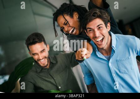 Portrait de jeunes employés diversifiés enthousiastes travailleurs dans un bureau moderne créatif. Consolidation d'équipe Banque D'Images
