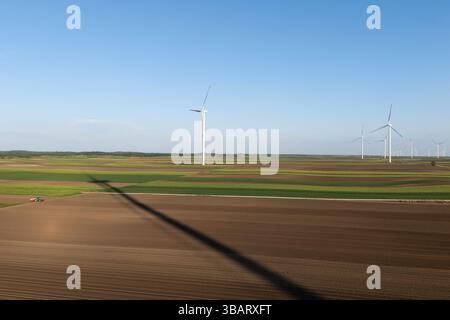 Le tracteur agricole travaille sur le terrain avec des éoliennes. Vue aérienne. Banque D'Images