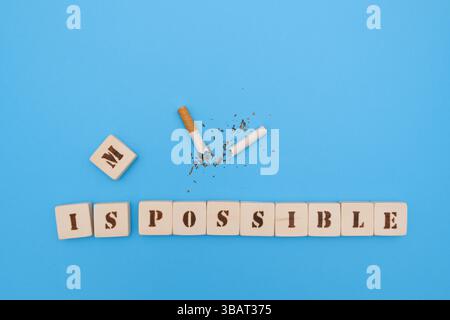 Cigarette cassée avec un message positif de lettres scrabble faites à la main, encourageant les gens à arrêter de fumer, sur un fond bleu. Banque D'Images