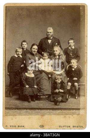Original cabinet victorien portrait studio de cartes de parents victoriens joyeux de classe moyenne victorienne, avec une grande famille de huit enfants, l'un d'eux un bébé. Grande famille victorienne. Père et mère victoriens. Enfance victorienne. Portrait de studio par C. (Cyrus) Voss Bark de Clifton, Bristol, royaume-uni circa 1888 de style vestimentaire. Banque D'Images