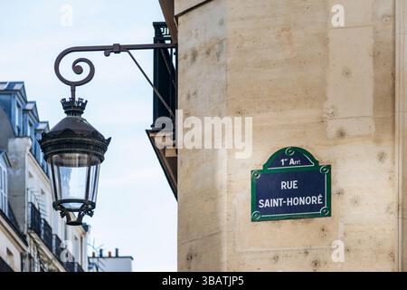 Panneau rue Saint-Honoré (en anglais : rue Saint-Honoré) et lanterne vintage sur bâtiment en pierre dans le 1er arrondissement de Paris Banque D'Images