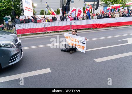 12 mai 2025, Varsovie, Pologne : un militant climatique du mouvement dernière génération (Ostatnie Pokolenie) bloque la voiture de Rafal Trzaskowski, maire de Varsovie et candidat à la présidence alors qu'il arrive pour le dernier débat présidentiel avant le jour des élections. À Woronicza 17, la chaîne de télévision publique polonaise TVP a organisé un grand débat pré-électoral avec des personnalités publiques et des candidats clés. Parmi les personnes présentes figuraient Artur Bartoszewicz, Magdalena Biejat, Grzegorz Braun, Szymon Holownia, Marek Jakubiak, Maciej Maciak, Slawomir Mentzen, Karol Nawrocki, Joanna Senyszyn, Krzysztof Stanowski, Rafal Trzaskowski Banque D'Images