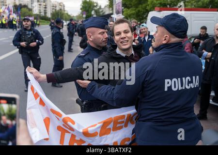 12 mai 2025, Varsovie, Pologne : des policiers retirent un militant climatique du mouvement de la dernière génération (Ostatnie Pokolenie) qui tentait de bloquer la voiture de Rafal Trzaskowski, maire de Varsovie et candidat à la présidentielle alors qu'il arrivait pour le dernier débat présidentiel avant le jour des élections. À Woronicza 17, la chaîne de télévision publique polonaise TVP a organisé un grand débat pré-électoral avec des personnalités publiques et des candidats clés. Parmi les personnes présentes figuraient Artur Bartoszewicz, Magdalena Biejat, Grzegorz Braun, Szymon Holownia, Marek Jakubiak, Maciej Maciak, Slawomir Mentzen, Karol Nawrocki, Joanna Senyszyn, Krzy Banque D'Images