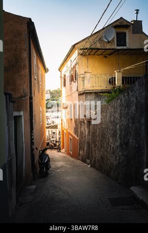 Veli Losinj, Croatie-25 juillet 2024 : belles ruelles étroites entourées de hauts murs en pierre dans la petite ville de Veli Losinj, Croatie Banque D'Images