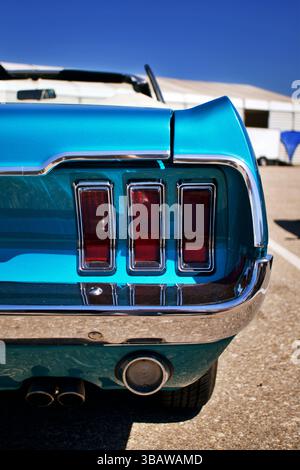 Vue arrière d'un cabriolet Ford Mustang bleu classique avec trois feux arrière emblématiques et pare-chocs chromés Banque D'Images