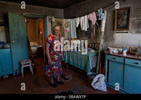 03.08.2023, Ukraine, oblast de Cherson, Myrolubimivka - reconstruction de maisons de village détruites. Une femme âgée se tient dans sa cuisine. 00U230803D003 Banque D'Images