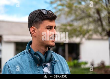 Un jeune homme élégant urbain heureux marche dans la rue de la ville. Banque D'Images