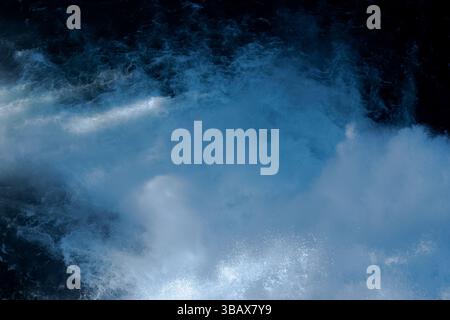 Gros plan de rapides fluviaux intenses avec des eaux vives moussantes et des courants bleus profonds. Banque D'Images