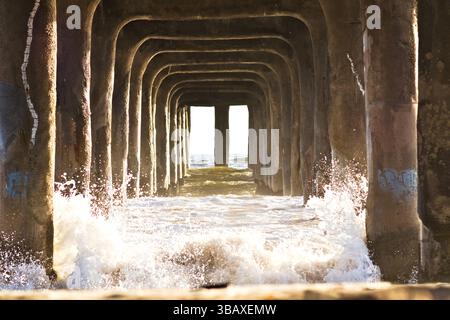Les vagues se brisent sous la jetée de Manhattan Beach Banque D'Images