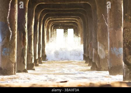 Les vagues se brisent sous la jetée de Manhattan Beach Banque D'Images
