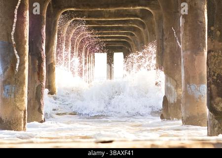 Les vagues se brisent sous la jetée de Manhattan Beach Banque D'Images