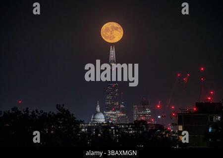 Londres, Royaume-Uni. 13 mai 2025. Météo britannique : « Flower Moon » à 98,2% monte au-dessus de la ville vu du nord-ouest de Londres. La pleine lune de ce mois est nommée, selon l’almanach du Old Farmer, pour les fleurs abondantes qui jaillissent ce mois-ci. Crédit : Guy Corbishley/Alamy Live News Banque D'Images