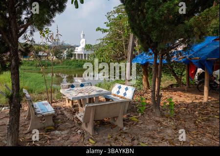 D'une table d'échiquier de jardin vers un grand bouddha blanc assis sur le dessus d'un petit temple à côté d'une rivière dans un hameau sur le sous-district de Mae Yao dans n Banque D'Images