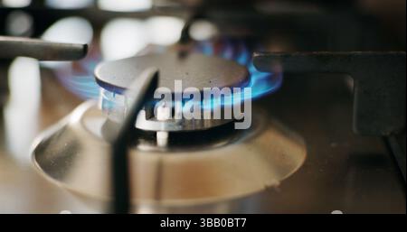Cuisine, cuisinière à gaz et gros plan avec feu pour la cuisine, la préparation des repas et le service dans le restaurant. Flamme bleue, appareil et machine avec chaleur sur la table de cuisson pour Banque D'Images