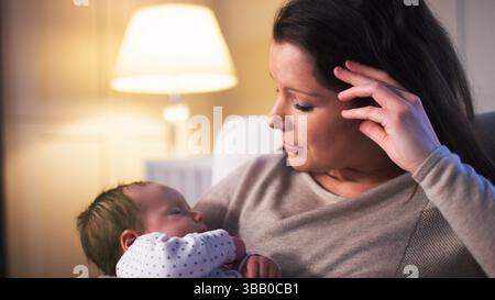 Nouvelle mère anxieuse souffrant de dépression post-natale tenant bébé garçon dans la pépinière à la maison Banque D'Images