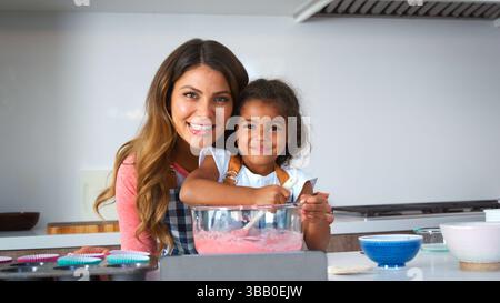 Portrait de mère hispanique et fille s'amusant dans la cuisine cuisson gâteau ensemble Banque D'Images