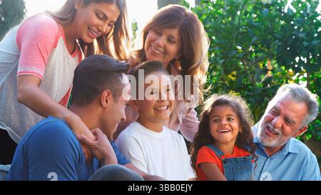 Famille hispanique multi-génération détente dans Garden at Home ensemble Banque D'Images