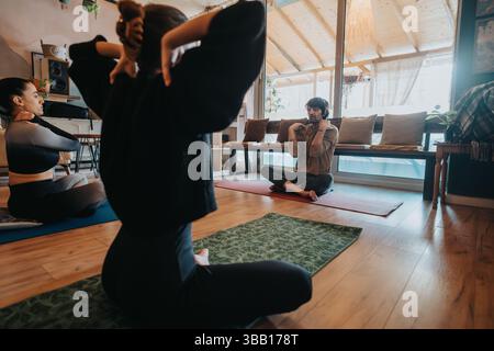 Séance de yoga en intérieur avec instructeur guidant un groupe dans un cadre serein et bien éclairé Banque D'Images
