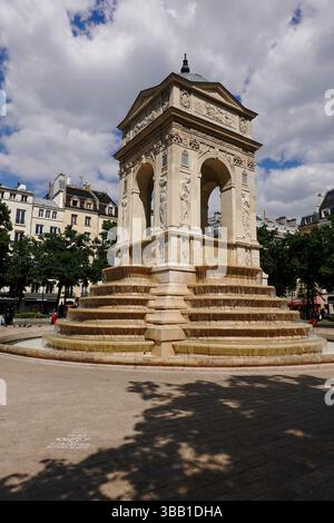Les gens assis autour de la Fontaine des innocents, fontaine publique sur la place Joachim-du-Bellay, quartier des Halles, 1er arrondissement, Paris, FR Banque D'Images