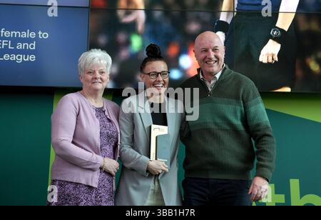 L'ancienne arbitre de football Rebecca Welch pose avec son prix et ses parents lors de sa cérémonie d'intronisation au Hall of Fame au National Football Museum de Londres. Date de la photo : mardi 12 novembre 2024. Banque D'Images