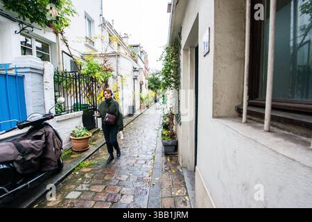 Paris, France. Femme marchant dans une ruelle de quartier. Banque D'Images