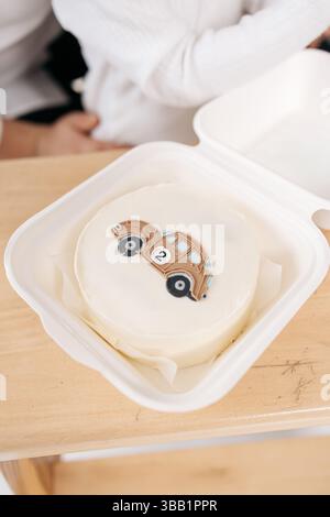 Petit gâteau au bento. avec une voiture. Mini gâteau sucré pour le garçon d'anniversaire. Gâteau glacé dans une boîte. Banque D'Images