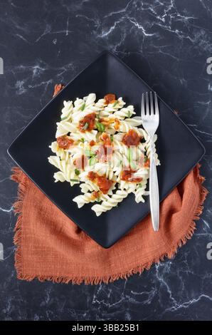 Pâtes fusilli sans gluten recouvertes de sauce tomate, garnies de basilic frais, ciboulette et persil Banque D'Images