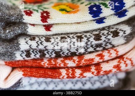 Chaussettes en laine empilées avec des motifs ukrainiens floraux et géométriques vibrants. Une photo détaillée de plusieurs chaussettes en laine affichant des couleurs vives Et Un visuel chaleureux Banque D'Images