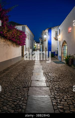 Portugal, région d'Oeste, Óbidos, architecture traditionnelle sur la Rua Direita à l'intérieur de la citadelle fortifiée historique la nuit Banque D'Images