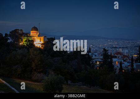 Vue panoramique de l'Observatoire National d'Athènes éclairé et du centre-ville d'Athènes en Grèce au crépuscule. Vue sur l'horizon urbain, la métropole et la ville pendant l'heure bleue. Banque D'Images