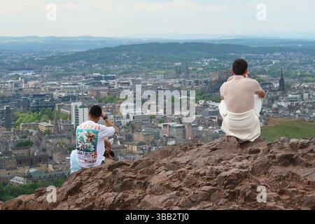 Arthur's Seat, Édimbourg, Écosse. Les jeunes regardent la vue sur la ville depuis le célèbre monument par un jour ensoleillé de printemps. Banque D'Images