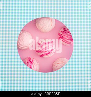 Composition estivale avec des cuillères de crème glacée à la fraise visibles à travers un espace en forme de cercle. Concept créatif de nourriture sucrée. Idée de dessert délicieux à la mode. Banque D'Images