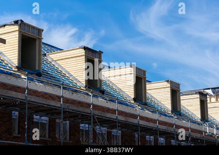 Lucarnes inachevées sur le toit partagé des maisons en rangée encore en construction Banque D'Images