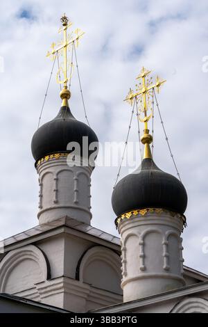 Dômes noirs d'un temple orthodoxe ou d'une église avec des croix dorées sur le ciel bleu. Photo de haute qualité Banque D'Images