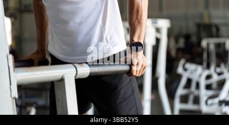 Bien-être et Fitness. Jeune homme effectuant des trempettes dans le gymnase pour la force du haut du corps. Banque D'Images