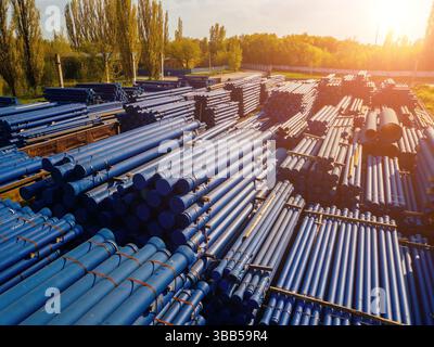 Pile de tuyaux en fonte dans la zone de chargement en attente de transport, vue aérienne du drone. Banque D'Images