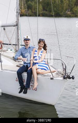 Jeune couple romantique posant sur le yacht Banque D'Images