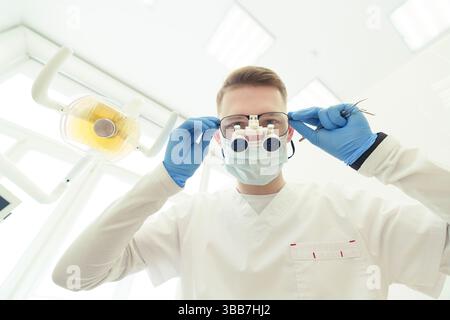 le dentiste se penche sur le patient et est sur le point de commencer l'examen Banque D'Images