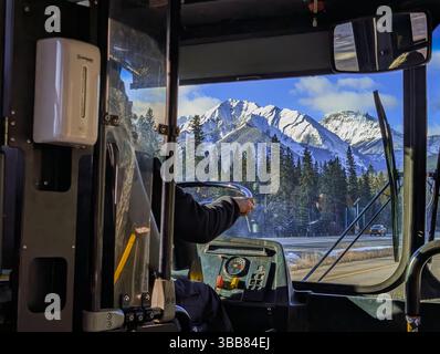Un chauffeur de bus méconnaissable exploitant une navette sur l'autoroute dans les montagnes - vue intérieure. Transit de transport en montagne. Concept de profession Banque D'Images