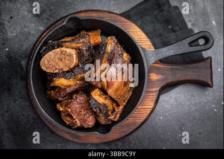 De courtes côtes de bœuf tendres dans une poêle, assaisonnées d'herbes et d'épices. Parfait pour les blogs culinaires ou les menus de restaurant qui se concentrent sur la viande copieux et savoureux d Banque D'Images