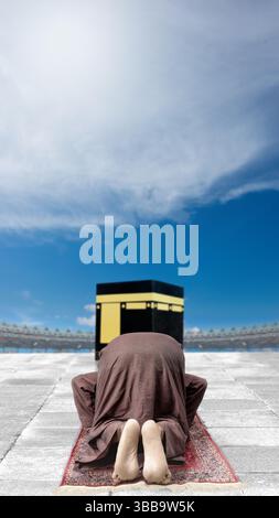 Vue arrière d'un homme musulman d'asie du Sud-est indonésien salant ou priant devant la Kaaba. Concept de hajj ou umrah Banque D'Images