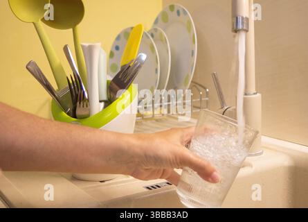 Un jet d'eau claire du robinet s'écoule doucement d'un robinet moderne. Banque D'Images